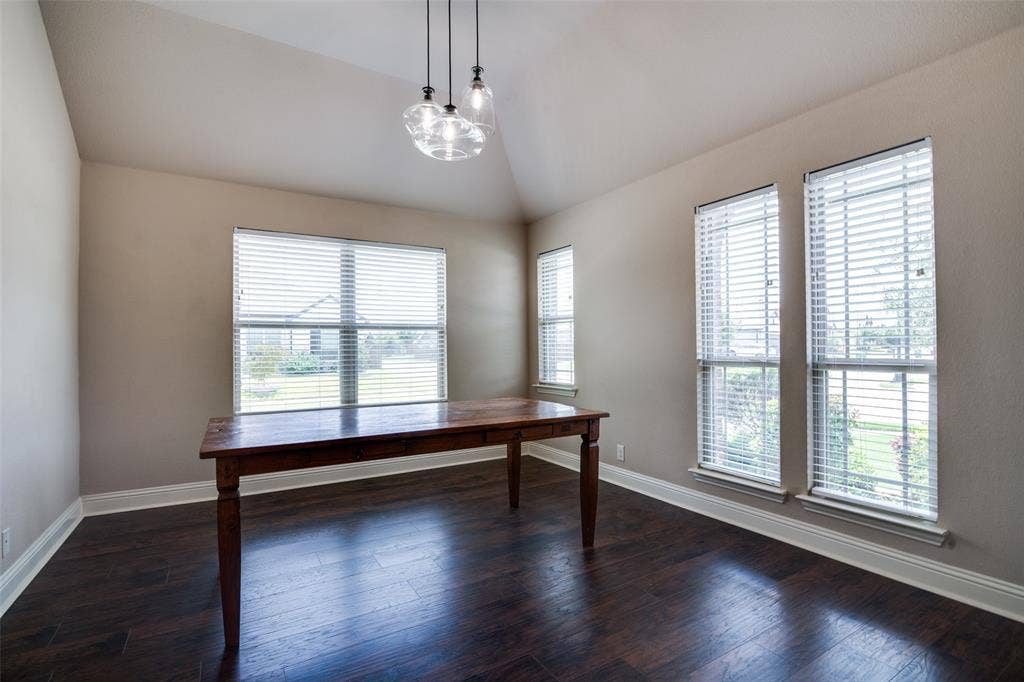 1813 Chadwick Lane, Forney, TX 75126 Vaulted ceiling, wood-finish flooring, multiple windows with blinds, and a contemporary pendant light fixture