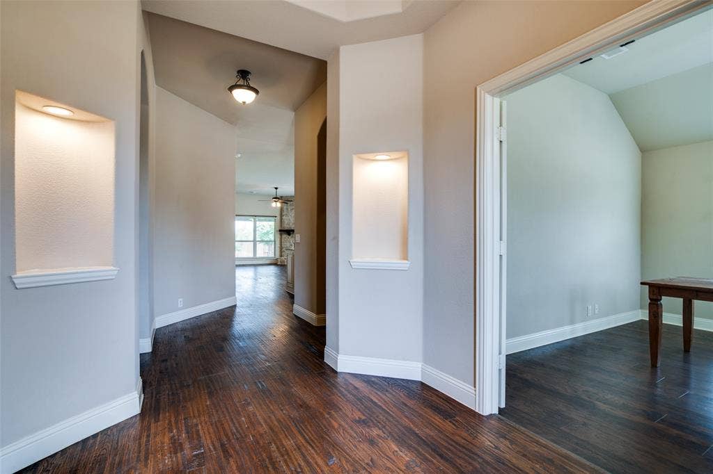 1813 Chadwick Lane, Forney, TX 75126 Wood-finish flooring throughout, arched hallways, recessed display niches with lighting, and a tray ceiling