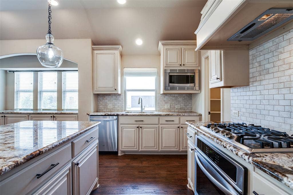 1813 Chadwick Lane, Forney, TX 75126 Kitchen featuring granite countertops, wood-finish flooring, white subway tile backsplash, recessed lighting, and stainless steel appliances