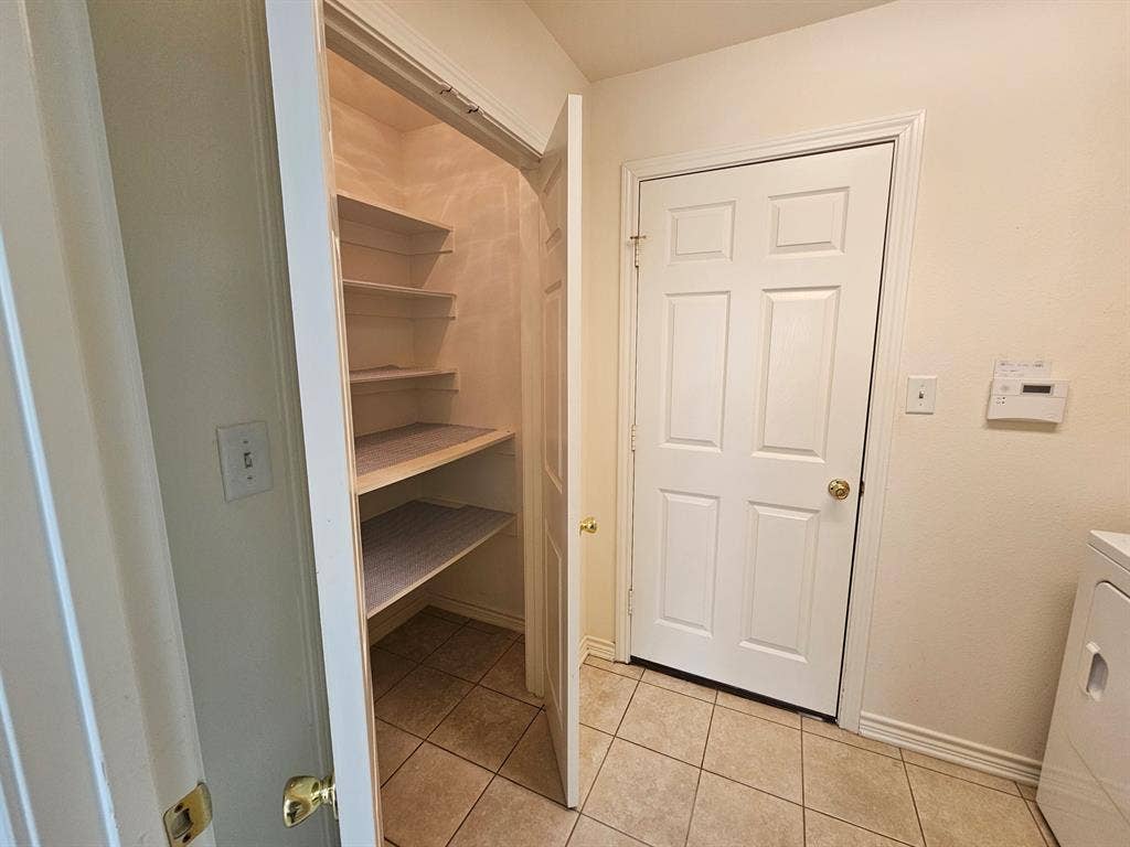 1521 Rice Road, #Z-101, Tyler, TX 75703 Built-in wood-finish cabinetry provides storage above laundry appliances
