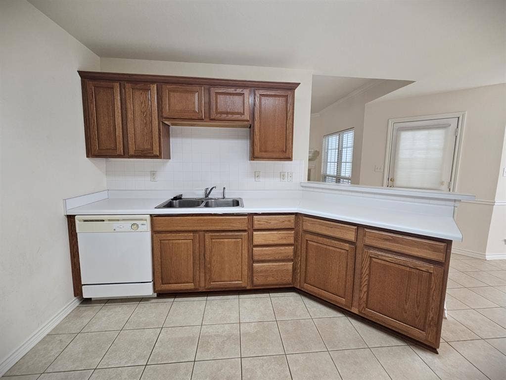 1521 Rice Road, #Z-101, Tyler, TX 75703 Kitchen featuring wood-finish cabinetry, white countertops, tile flooring, and white appliances