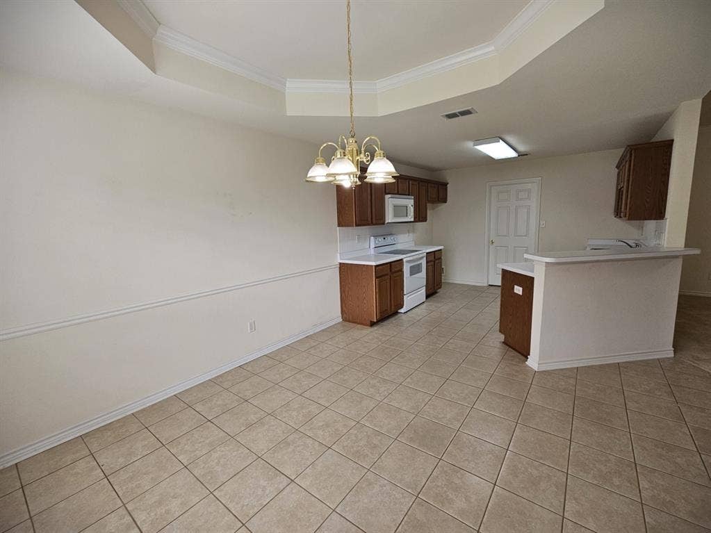 1521 Rice Road, #Z-101, Tyler, TX 75703 Wood-finish cabinetry, white countertops, a double basin sink, and a white dishwasher