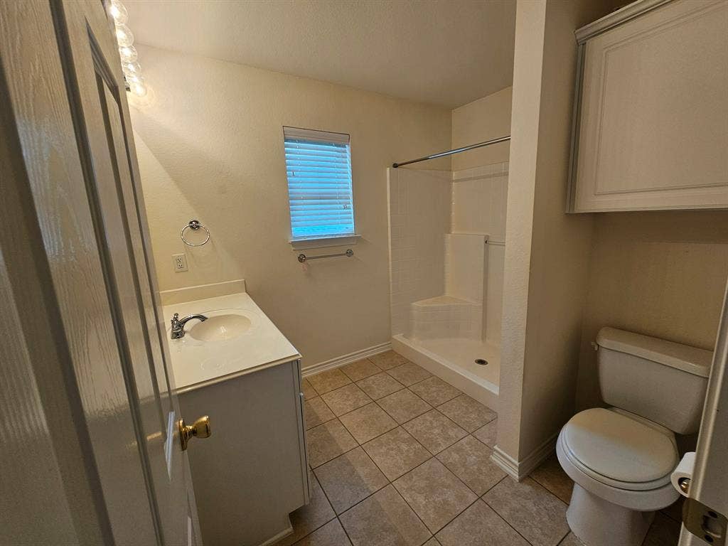 1521 Rice Road, #Z-101, Tyler, TX 75703 Spacious garage with polished concrete flooring, wall-mounted storage cabinetry, overhead lighting, and an automatic garage door opener
