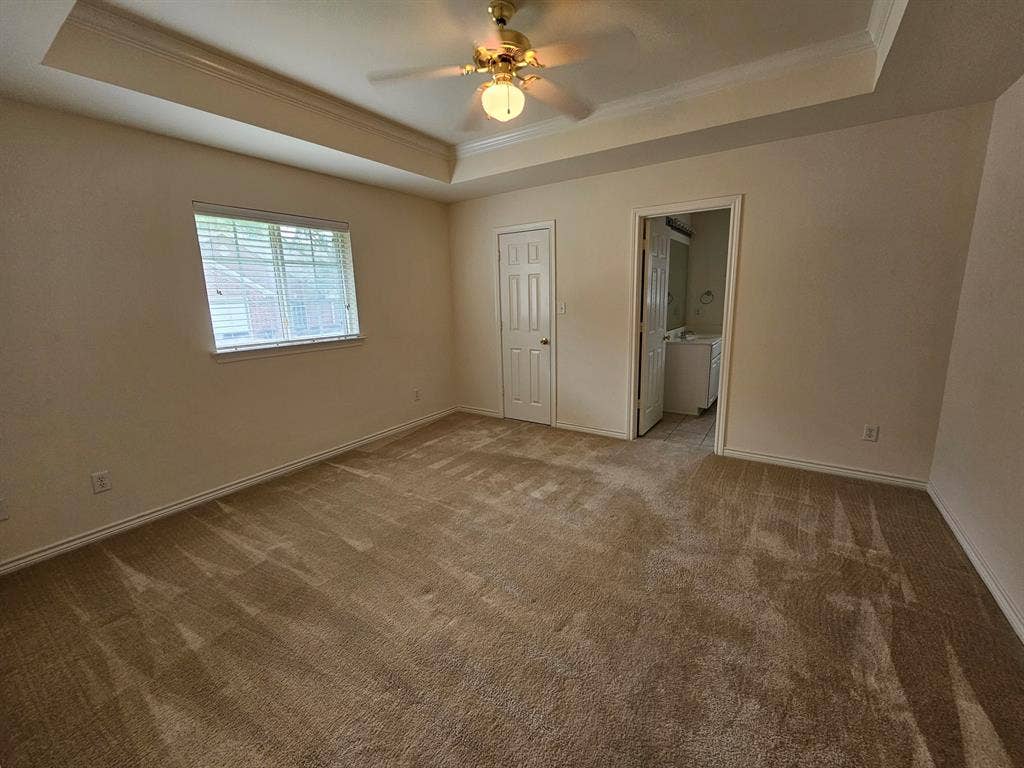 1521 Rice Road, #Z-101, Tyler, TX 75703 Recessed ceiling detail with crown molding, ceiling fan with light fixture, and neutral carpeted flooring