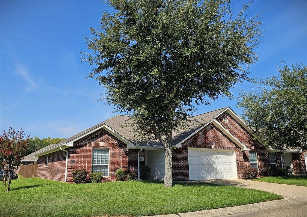 1521 Rice Road, #Z-101, Tyler, TX 75703 Expansive lawn bordered by a wood privacy fence, featuring a brick exterior and sliding glass door access