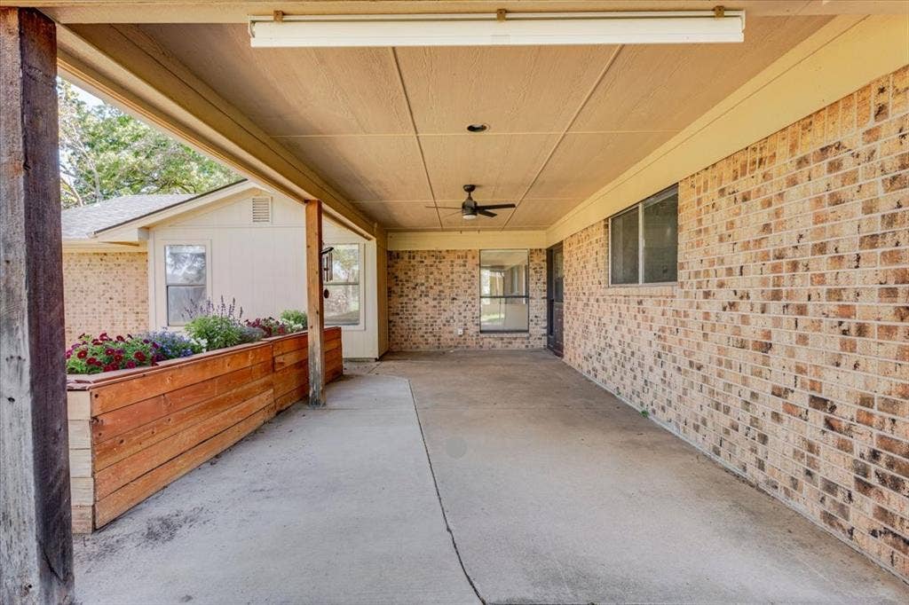 Covered patio with brick siding, concrete flooring, recessed lighting, and a ceiling fan