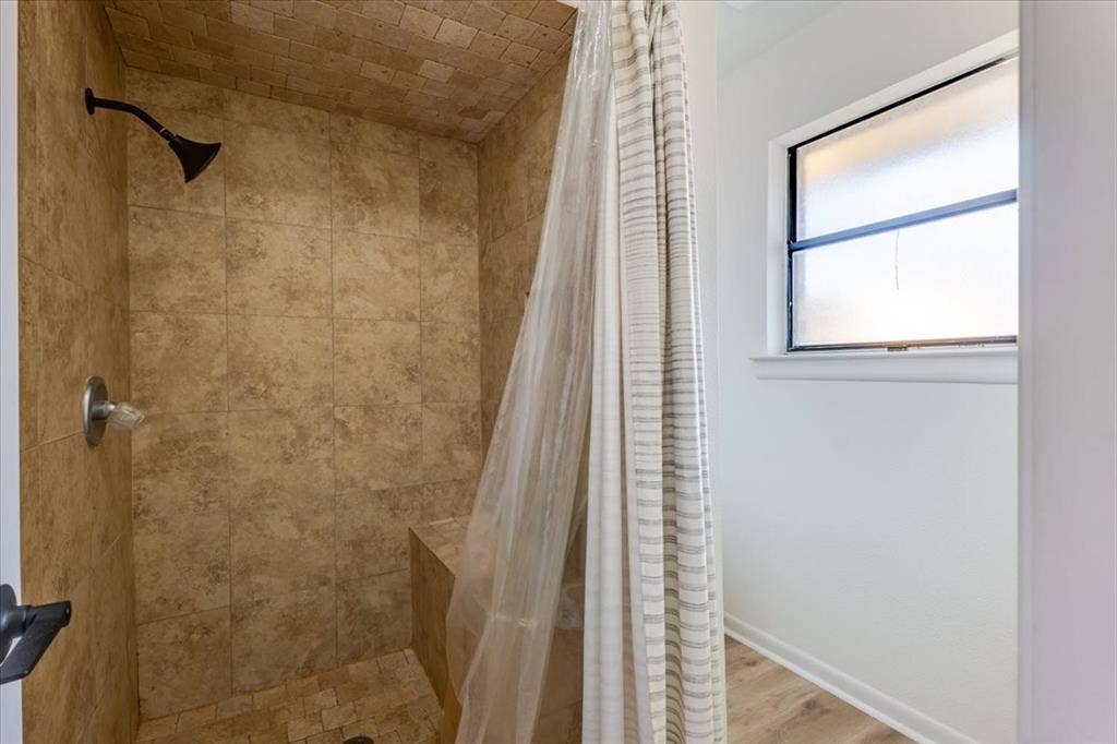 Tiled shower with a built-in bench and a dark bronze shower head