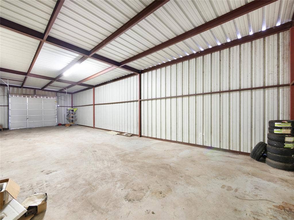 2944 CR-596, Nevada, TX 75173 Expansive interior featuring a concrete floor, corrugated metal walls, exposed structural beams, and overhead lighting