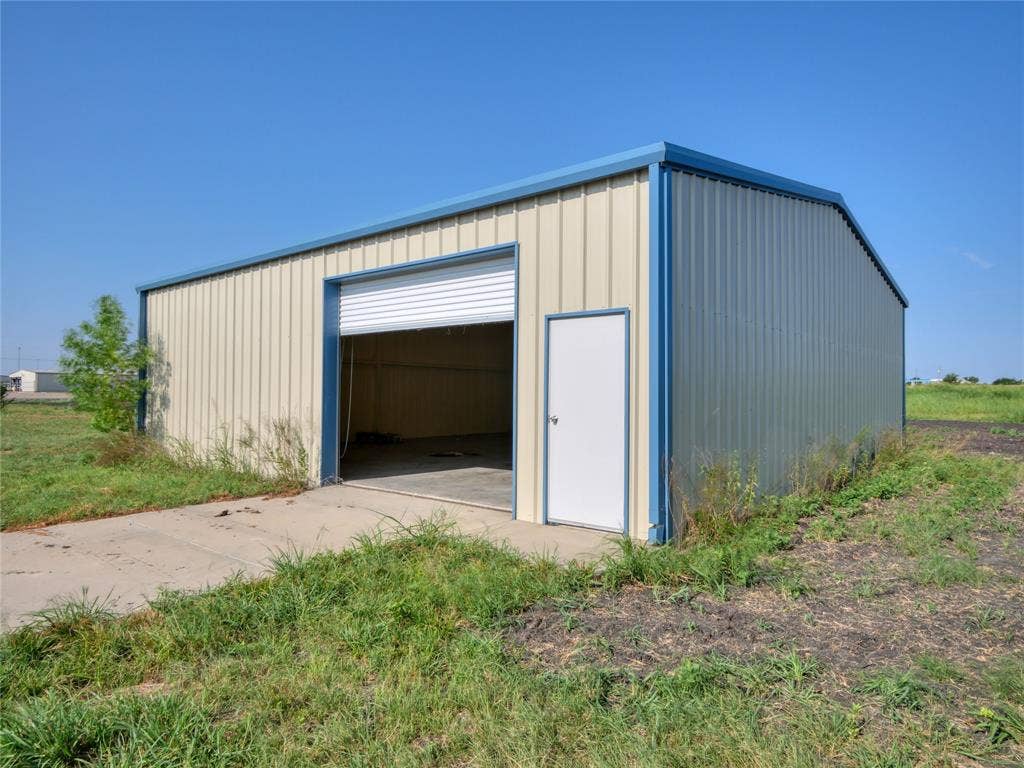 2944 CR-596, Nevada, TX 75173 Metal utility building with a roll-up door, pedestrian entry door, and concrete pad