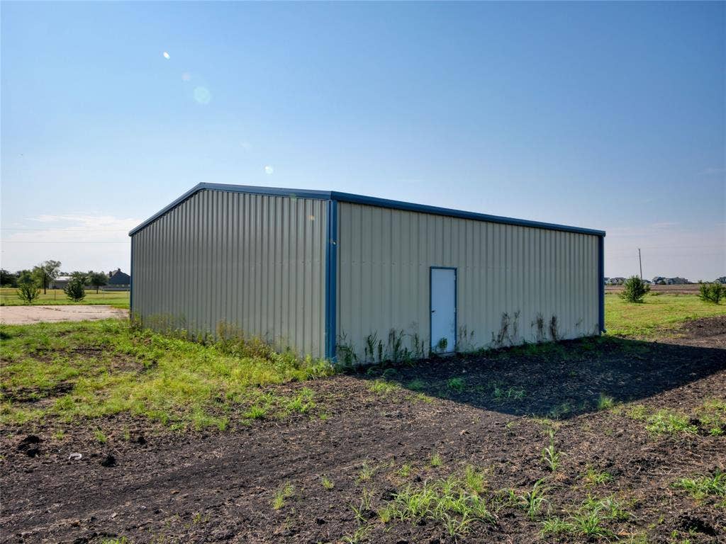 2944 CR-596, Nevada, TX 75173 Freestanding metal building with a single entry door and perimeter trim