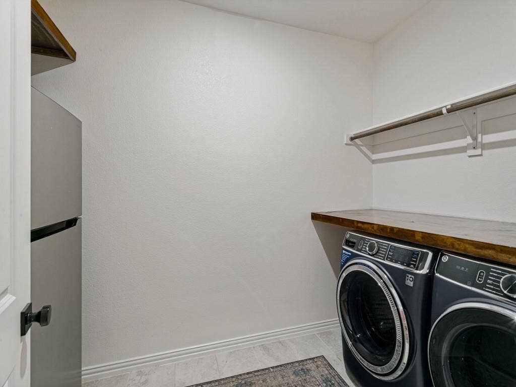 5513 Baker Creek Road, Fort Worth, TX 76126 Laundry area with tile flooring, wood-finish countertop, and wall-mounted shelving
