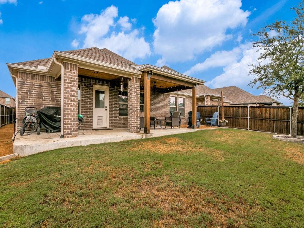 5513 Baker Creek Road, Fort Worth, TX 76126 Brick exterior with covered patio, wood posts, and a fenced backyard