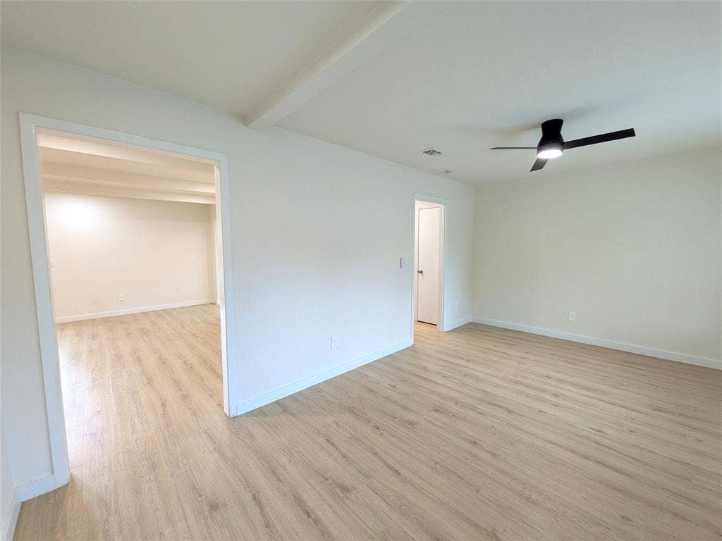 1400 Oakhill Drive, Plano, TX 75075 Bright interior space featuring light wood-finish flooring, white walls, and a modern black ceiling fan with integrated lighting