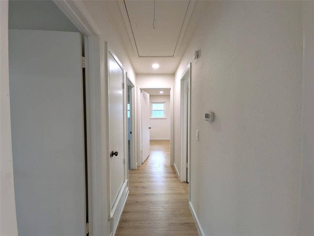 1400 Oakhill Drive, Plano, TX 75075 Hallway featuring wood-finish flooring, recessed lighting, white walls, and multiple panel doors
