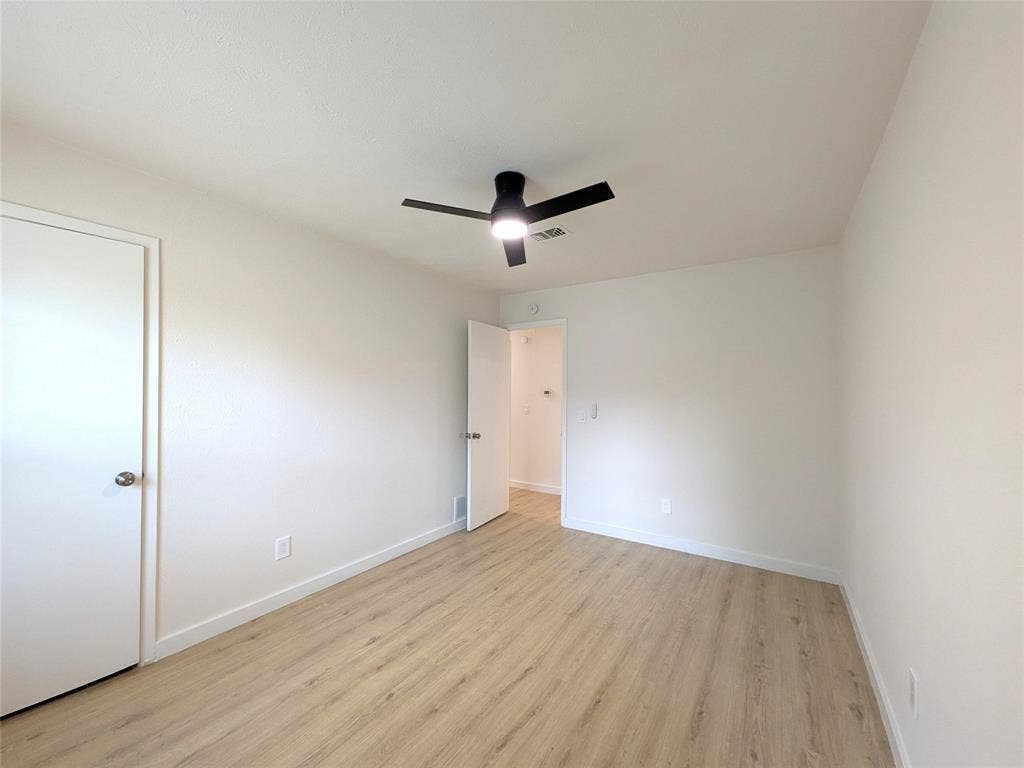 1400 Oakhill Drive, Plano, TX 75075 Bright interior room featuring wood-finish flooring, white walls, and a contemporary ceiling fan