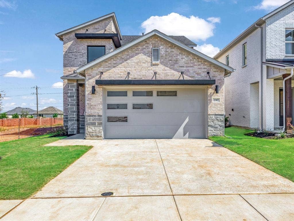 2317 Peters Colony Drive, Little Elm, TX 75036 View of front of house with an attached garage, concrete driveway, and stone siding