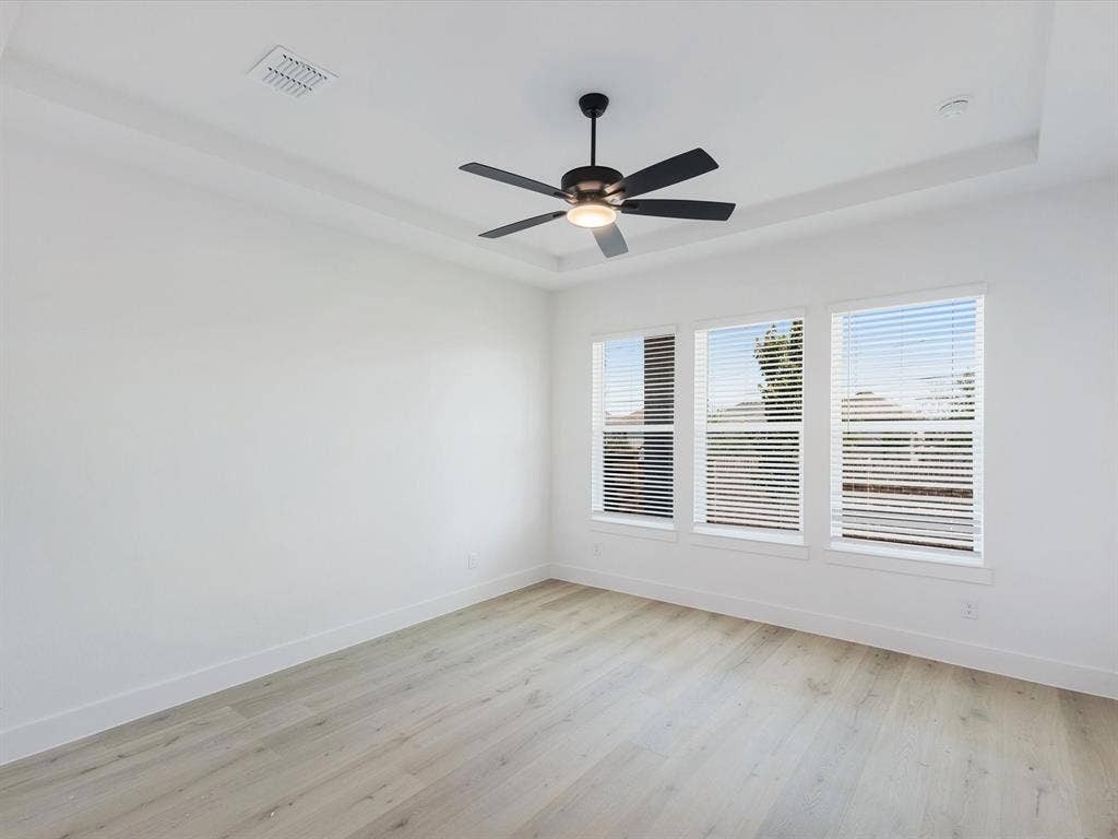2317 Peters Colony Drive, Little Elm, TX 75036 Primary Bedroom with light wood finished floors, a raised ceiling, and ceiling fan