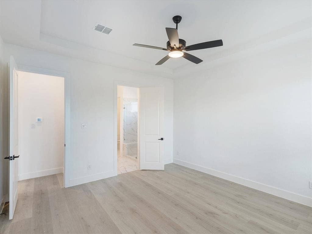 2317 Peters Colony Drive, Little Elm, TX 75036 Primary bedroom featuring light wood-style floors, ceiling fan, and ensuite bath