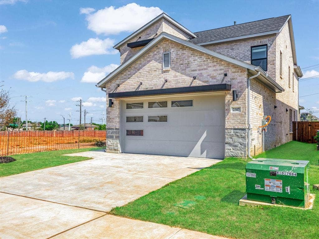 2317 Peters Colony Drive, Little Elm, TX 75036 View of front of home featuring concrete driveway, an attached garage, brick siding, and roof with shingles