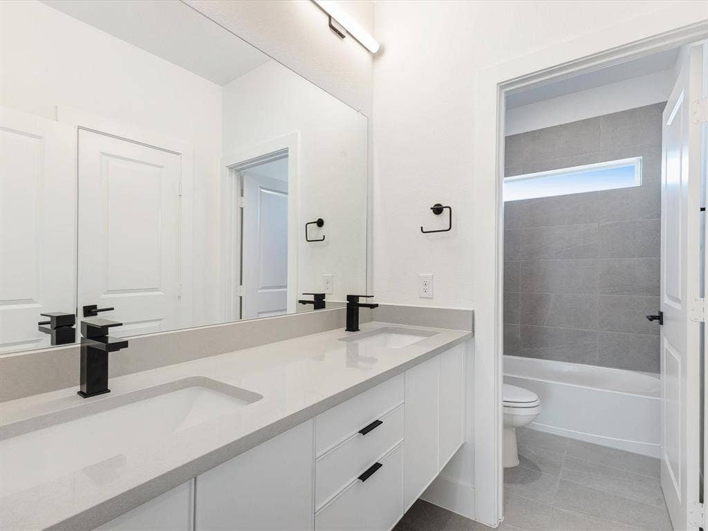 2317 Peters Colony Drive, Little Elm, TX 75036 Bathroom featuring light tile patterned floors and washtub / shower combination