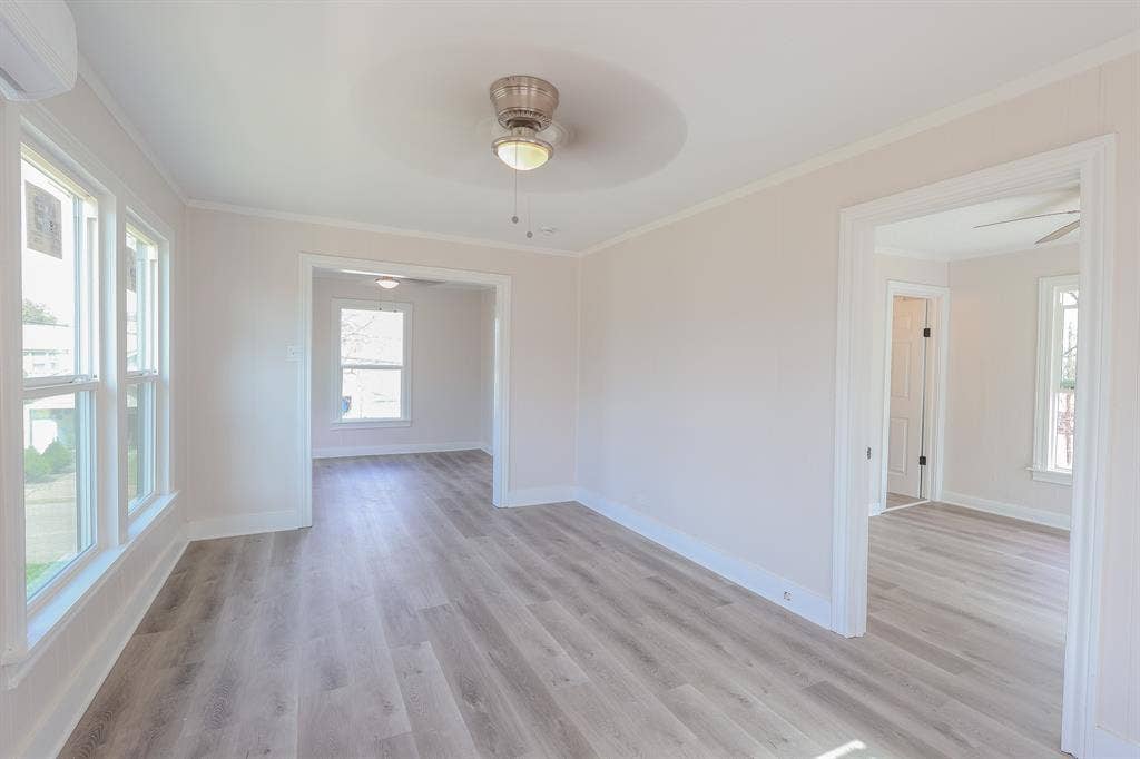 1704 Ethel Avenue, #B, Waco, TX 76707 Light-toned wood-finish flooring, white window trim, and a ceiling fan with integrated lighting