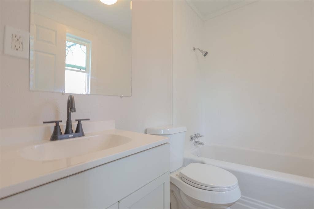 1704 Ethel Avenue, #B, Waco, TX 76707 Vanity with a single basin sink, matte black faucet, and frameless rectangular mirror