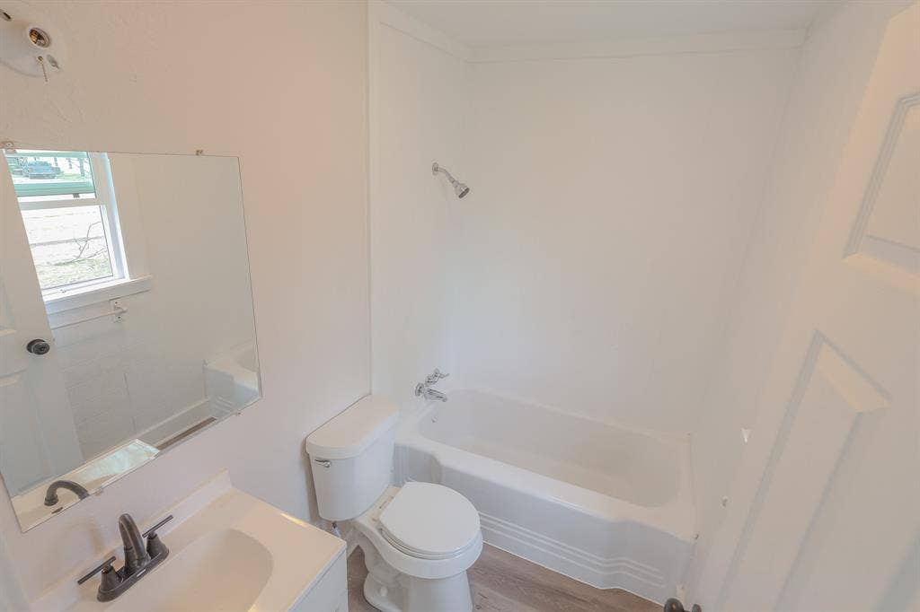 1704 Ethel Avenue, #B, Waco, TX 76707 White bathroom vanity with integrated sink, contemporary matte black faucet, and a wall-mounted mirror