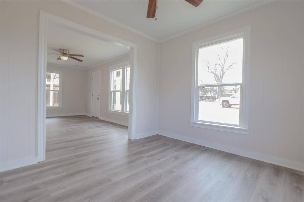 1704 Ethel Avenue, #B, Waco, TX 76707 Bright, open living spaces featuring gleaming wood-finish flooring throughout, abundant natural light from multiple windows, ceiling fan, and clean white walls and trim