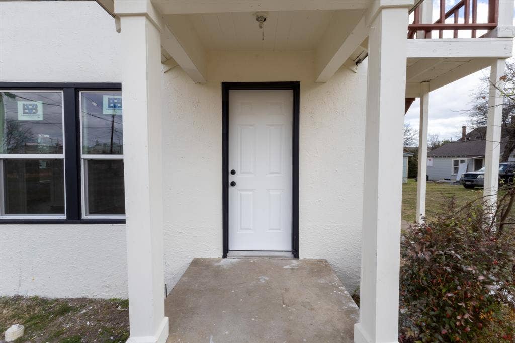 1704 Ethel Avenue, #B, Waco, TX 76707 Covered entry with concrete flooring, white paneled door, and black window frames