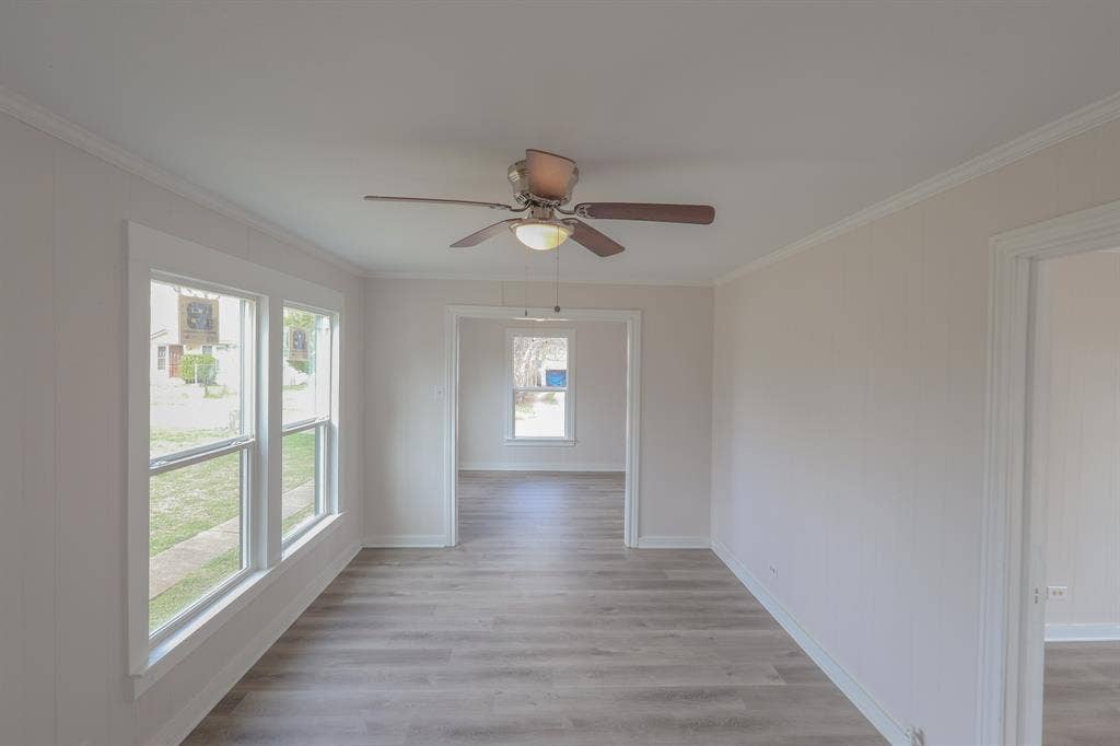 1704 Ethel Avenue, #B, Waco, TX 76707 Wood-finish flooring, ceiling fan with integrated lighting, multiple windows, and white trim throughout