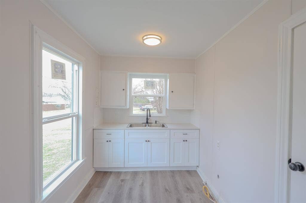 1704 Ethel Avenue, #B, Waco, TX 76707 Bright and airy bathroom featuring a white cabinetry vanity with dual sink configuration, polished countertop, and chrome fixtures