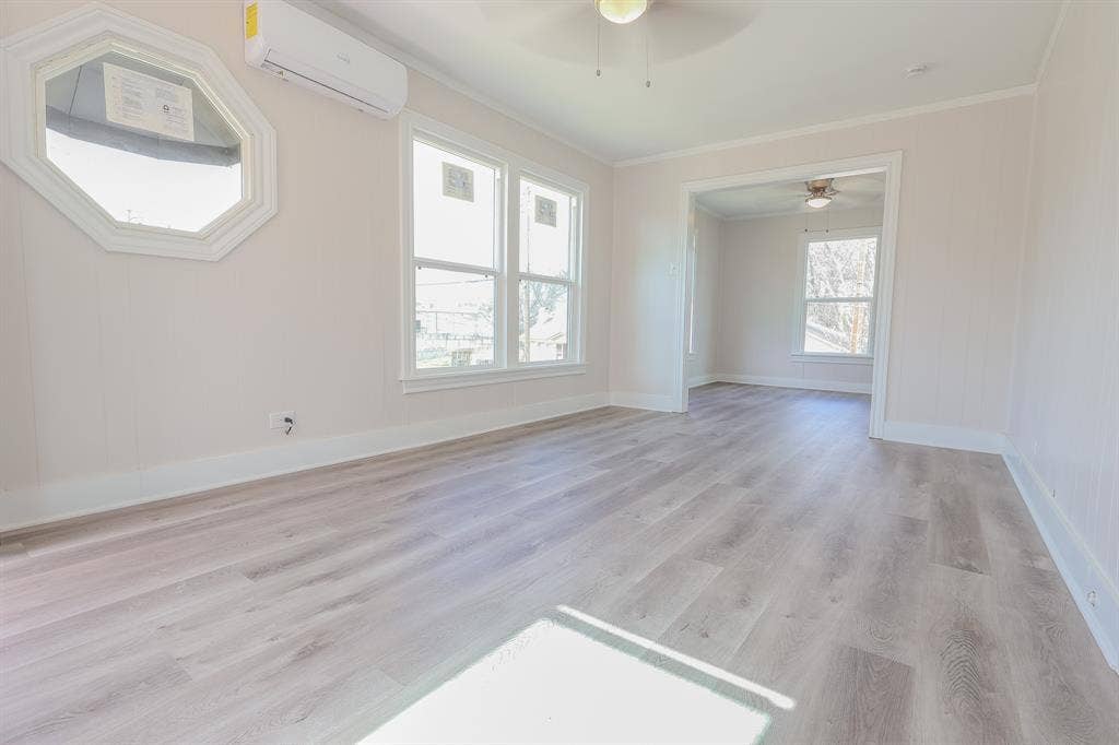 1704 Ethel Avenue, #B, Waco, TX 76707 Wood-finish flooring throughout, multiple windows providing natural light, and a ceiling fan