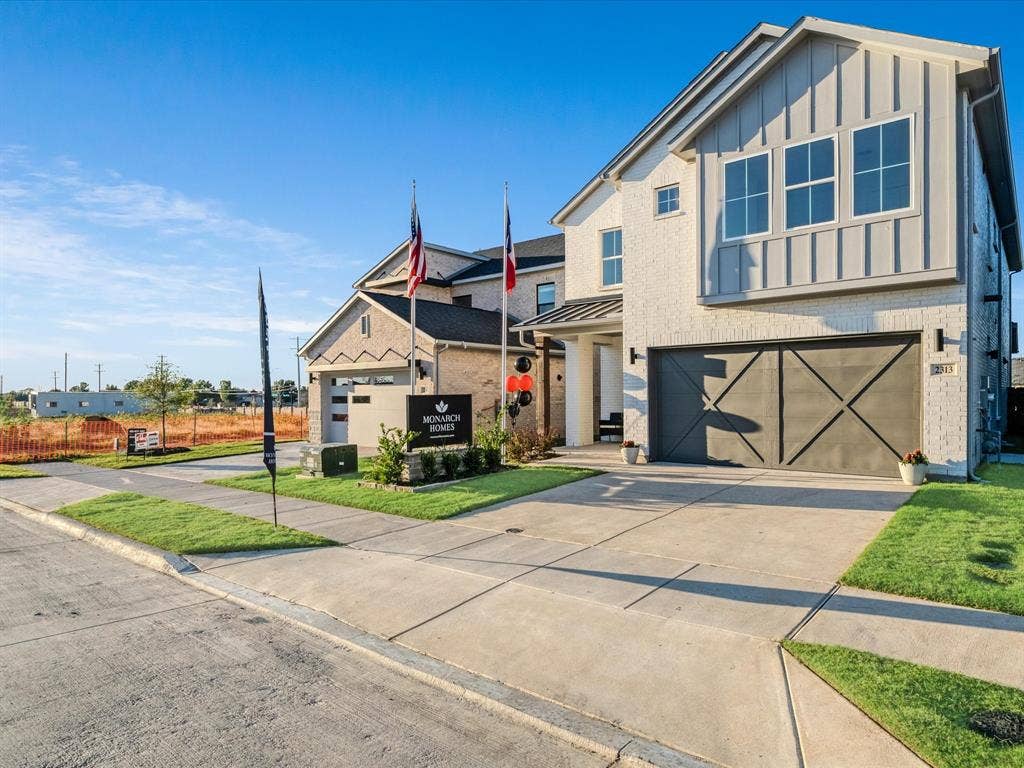 2313 Peters Colony Drive, Little Elm, TX 75036 View of front of house with brick siding, board and batten siding, driveway, a standing seam roof, and a garage