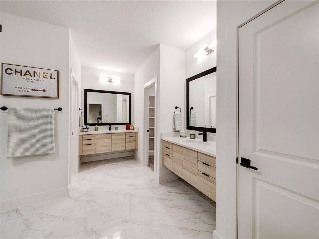 2313 Peters Colony Drive, Little Elm, TX 75036 Bathroom featuring two vanities and light marble finish floors
