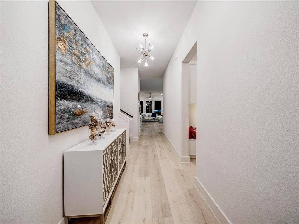 2313 Peters Colony Drive, Little Elm, TX 75036 Corridor featuring light wood-type flooring and a chandelier