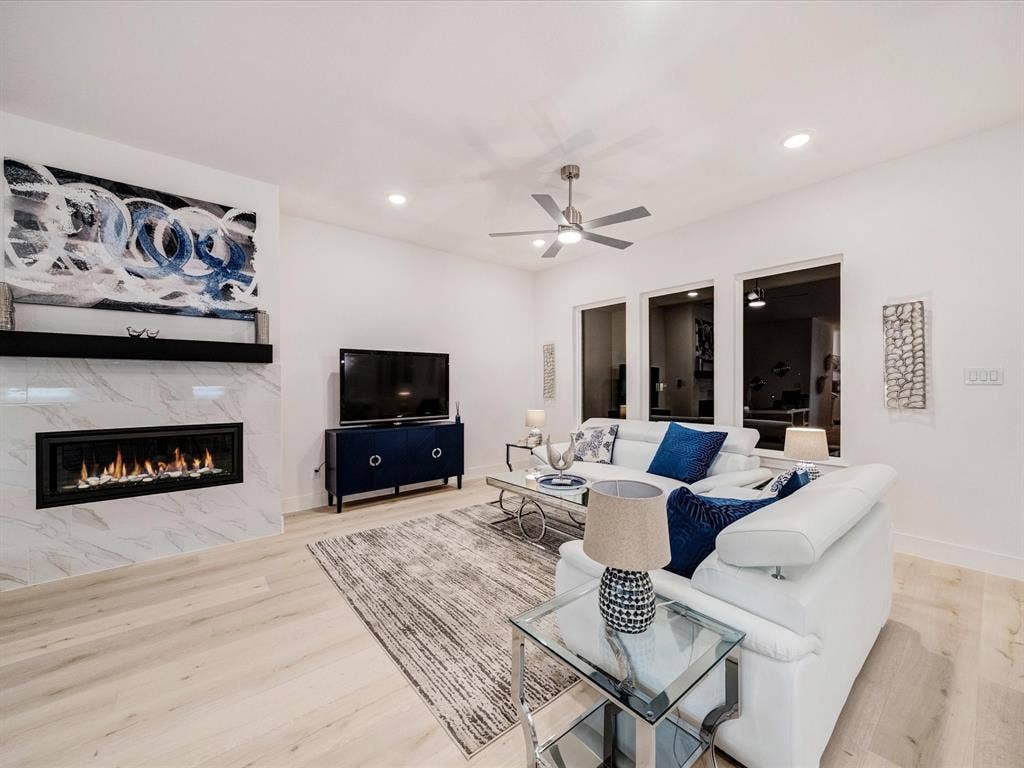 2313 Peters Colony Drive, Little Elm, TX 75036 Living area with a high end fireplace, light wood-type flooring, recessed lighting, and a ceiling fan