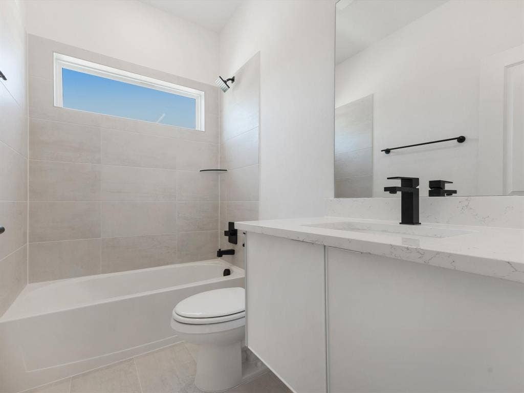 Ensuite Bathroom with tub / shower combination, vanity, and light tile patterned floors