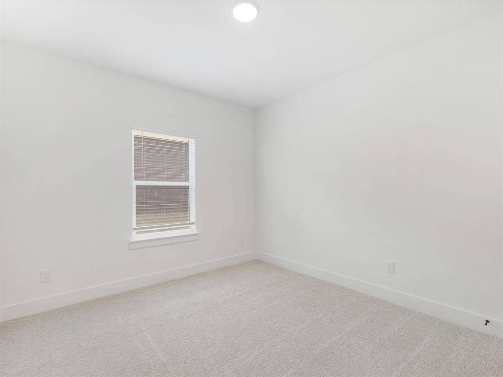 Bedroom 4 with baseboards and light carpet