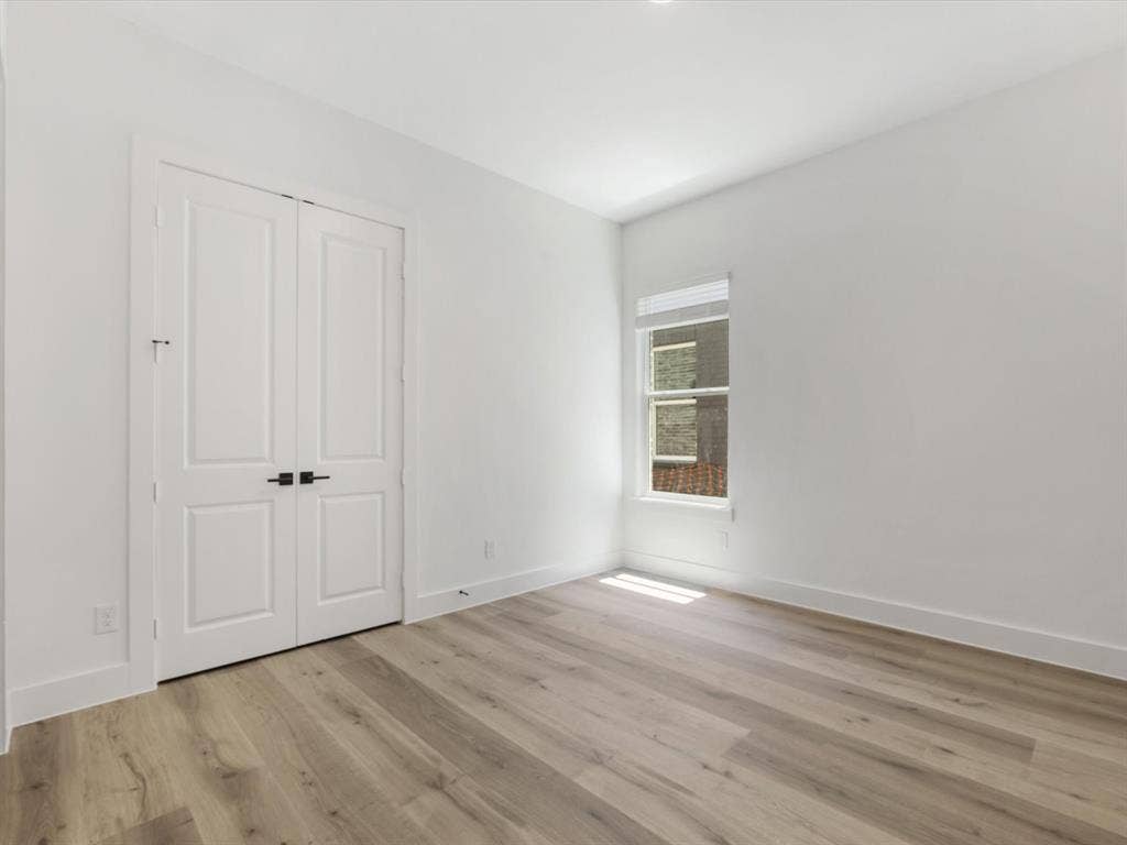 Downstairs Mother in law suite with ensuite bath featuring light wood finished floors and a closet