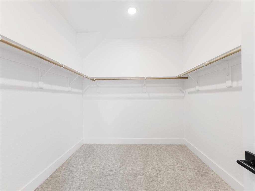 Walk in closet featuring light colored carpet