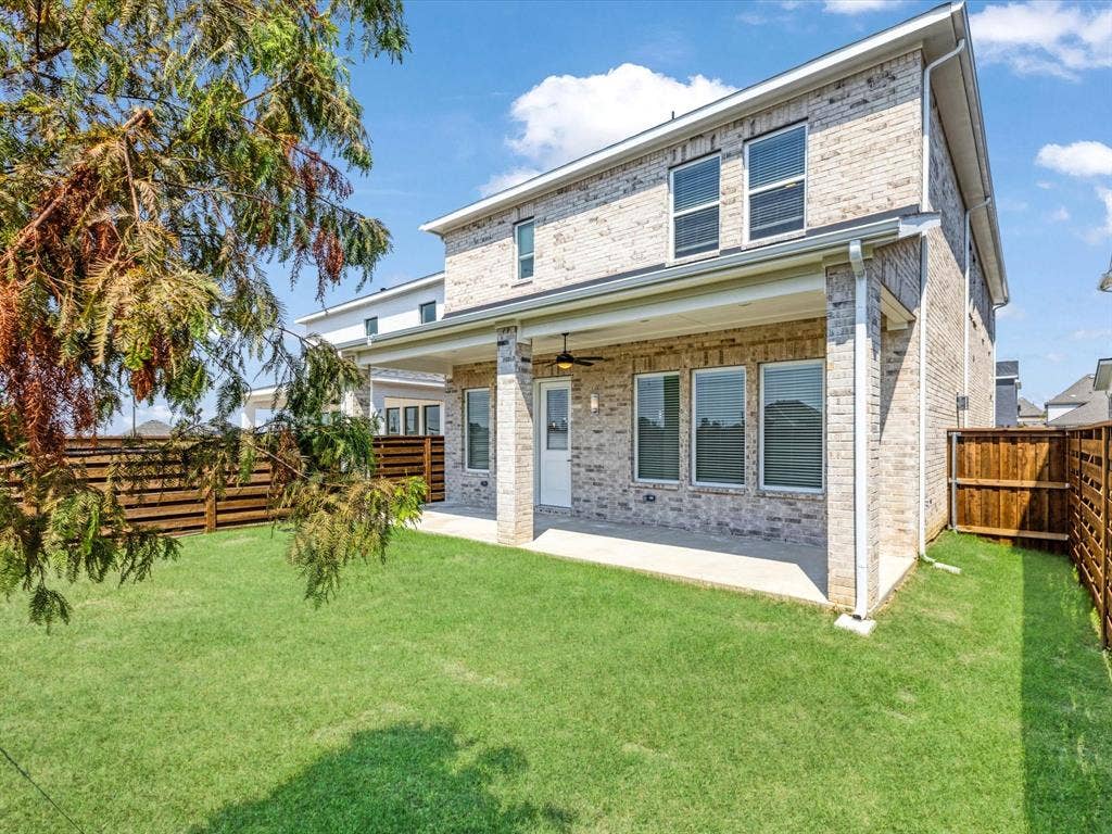 Back of house featuring a patio area, brick siding, a fenced backyard, and a ceiling fan
