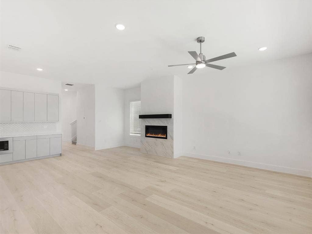 Living room with gas fireplace, recessed lighting, light wood-style floors, and ceiling fan
