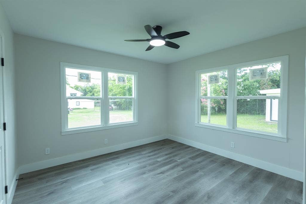 1716 Ethel Avenue, #1714, 1718, 1720, Waco, TX 76707 Room featuring wood-finish flooring, two large windows, a ceiling fan with integrated lighting, and light-toned walls