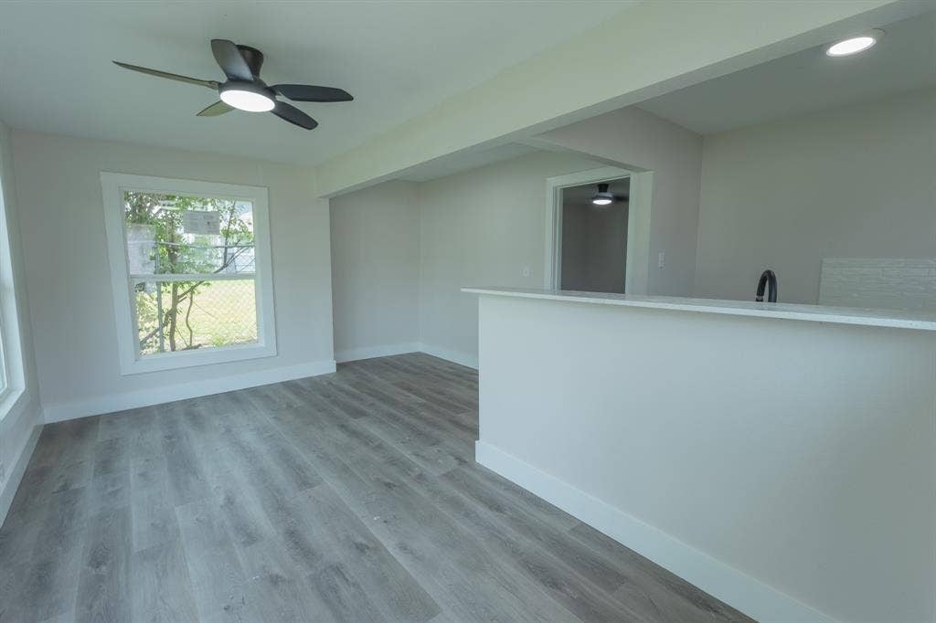 1716 Ethel Avenue, #1714, 1718, 1720, Waco, TX 76707 Open-concept living space featuring wood-finish flooring, a contemporary ceiling fan, and a pass-through counter with a sink