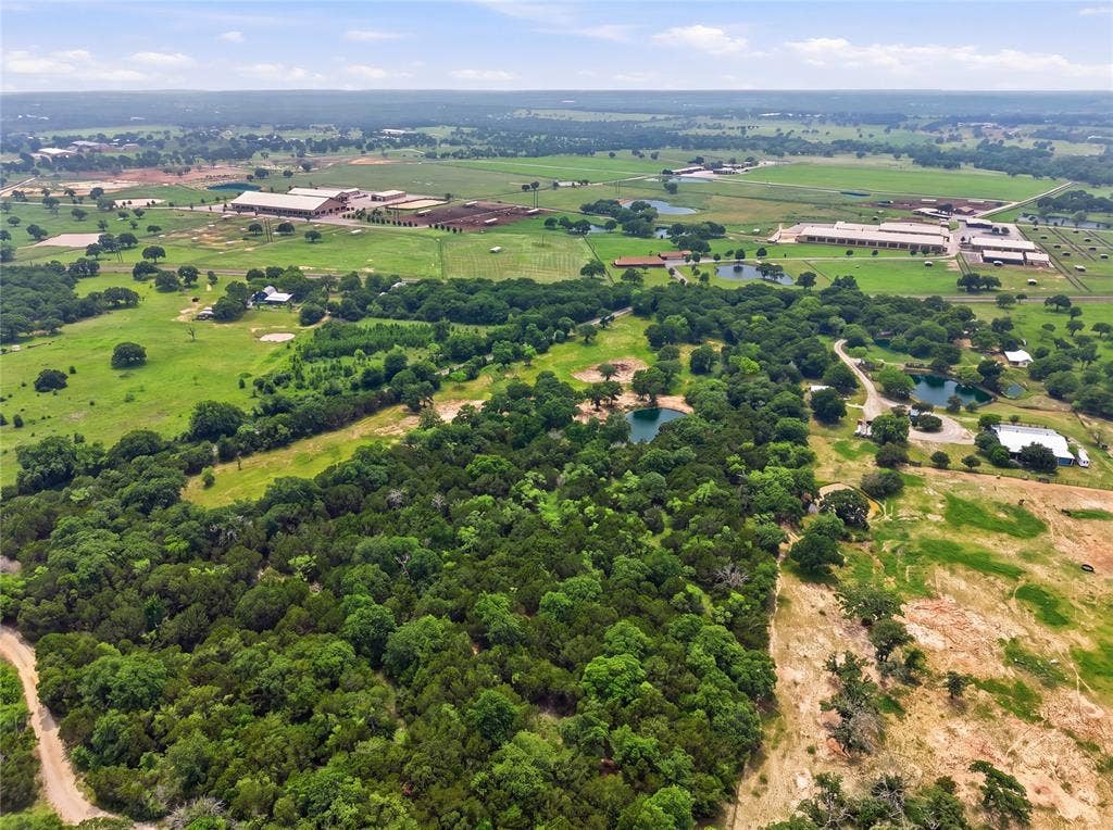 TBD Manley Road, Weatherford, TX 76088 Expansive acreage featuring dense woodlands, open pastures, multiple ponds, and distant agricultural structures