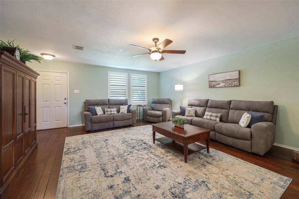5409 Running Brook Lane, McKinney, TX 75071 Wood-finish flooring throughout, featuring a ceiling fan with integrated lighting, and window shutters