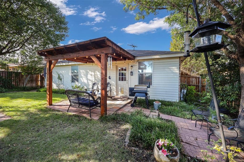 5409 Running Brook Lane, McKinney, TX 75071 Expansive backyard featuring a wood pergola, brick paver patio, established landscaping, and privacy fencing