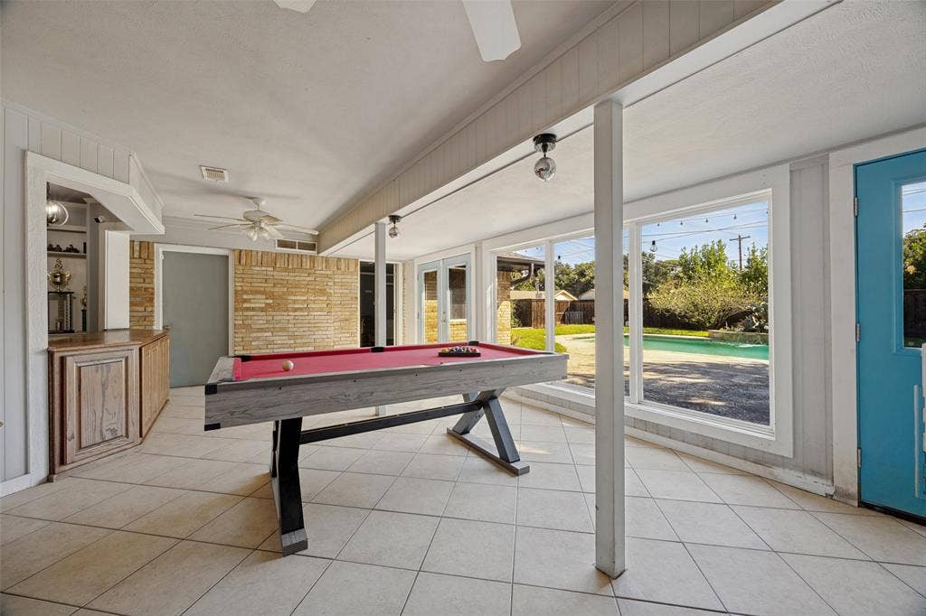 6401 Stonewall Street, Greenville, TX 75402 Spacious room with tile flooring, built-in bar, and extensive window-frontage