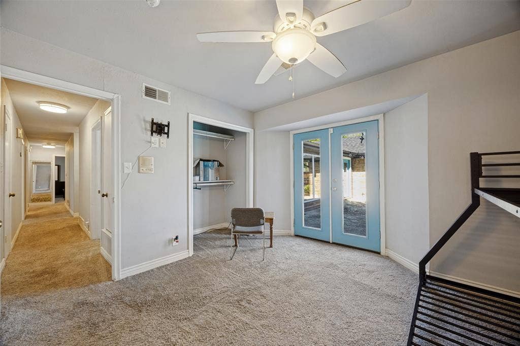 6401 Stonewall Street, Greenville, TX 75402 Plush carpeted flooring, a ceiling fan with integrated lighting, and light blue French doors leading to exterior