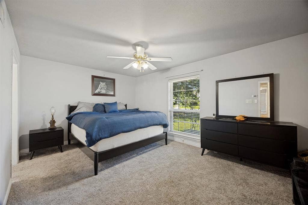 6401 Stonewall Street, Greenville, TX 75402 Plush carpet flooring, a window with blinds, and a ceiling fan with integrated lighting